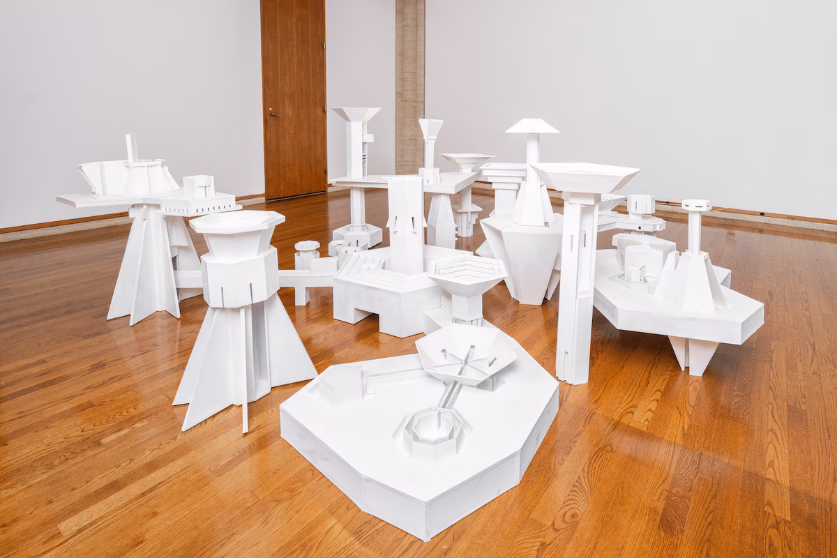 A collection of white sculptures displayed on a wooden floor.